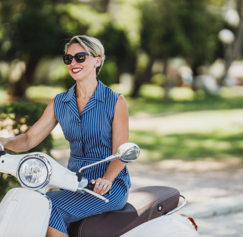 Woman Riding A Vintage Scooter Woman Riding A Vintage Scooter